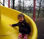 On the slide at the park across the street