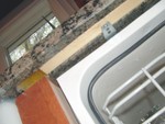 FYI - the dishwasher is mounted to a strip of wood embedded in some kind of plastic material that is set into a track that was cut into the underside of the granite in front of the dishwasher.  Nothing shows under the counter.