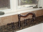 Concinnity Strathmore faucet in oil rubbed bronze with side spray.  It works well, the finish is flawless. The company went out of business!?