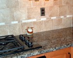 Tile backsplash (Atlas Concorde Elementi), baltic brown granite, oil rubbed bronze outlet covers.  Stoneware salt pig.